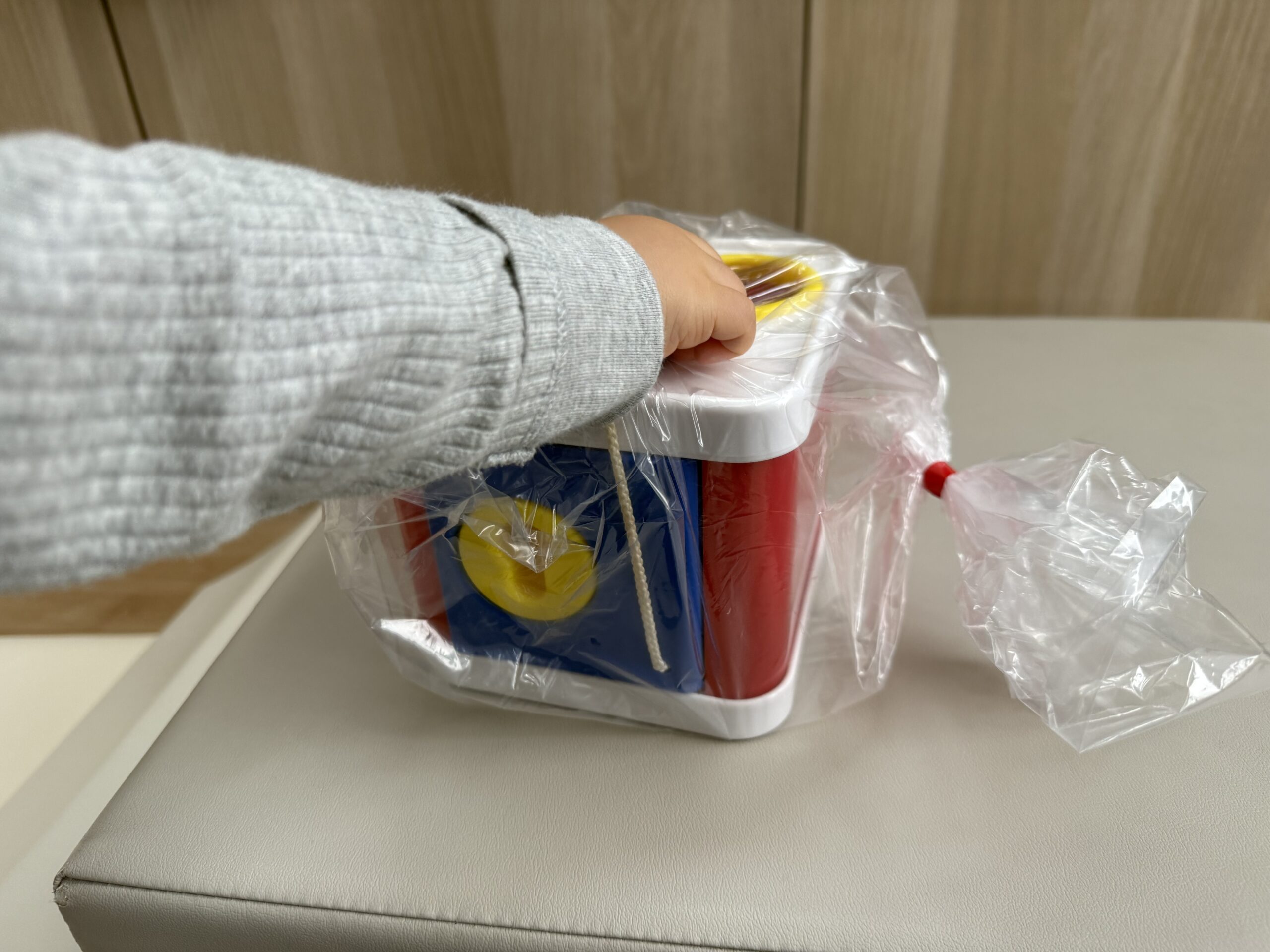 梱包されたおもちゃを取り出す息子の手