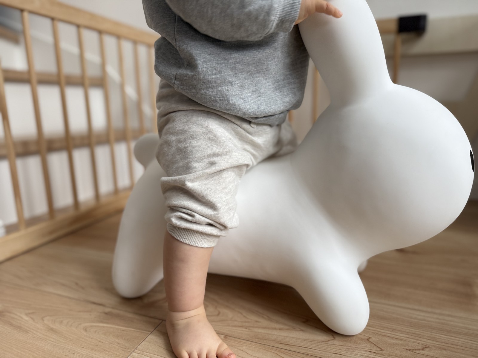 ブルーナボンボンにまたがろうとする1歳の子ども