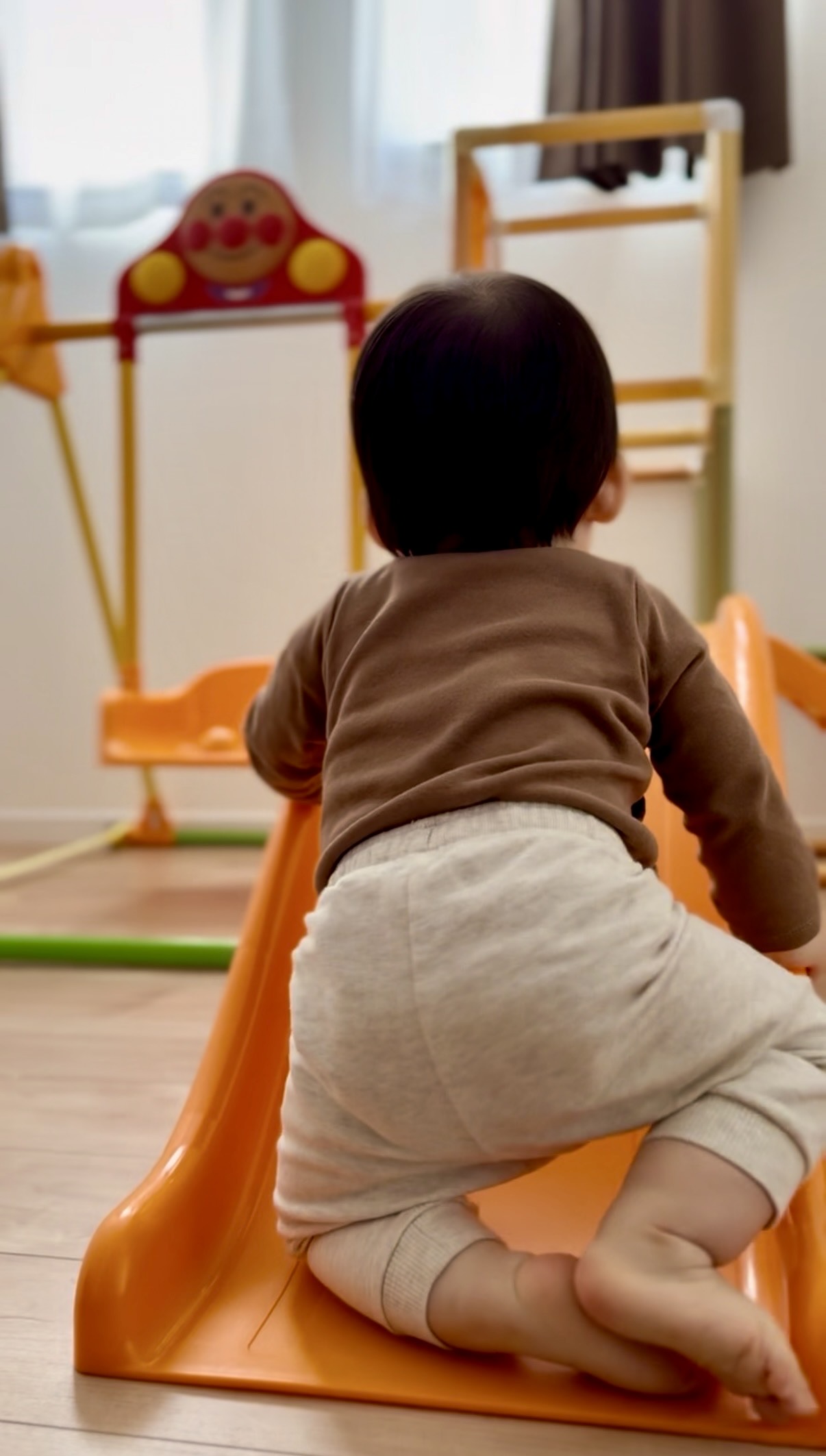 すべり台を登ろうとする1歳の息子