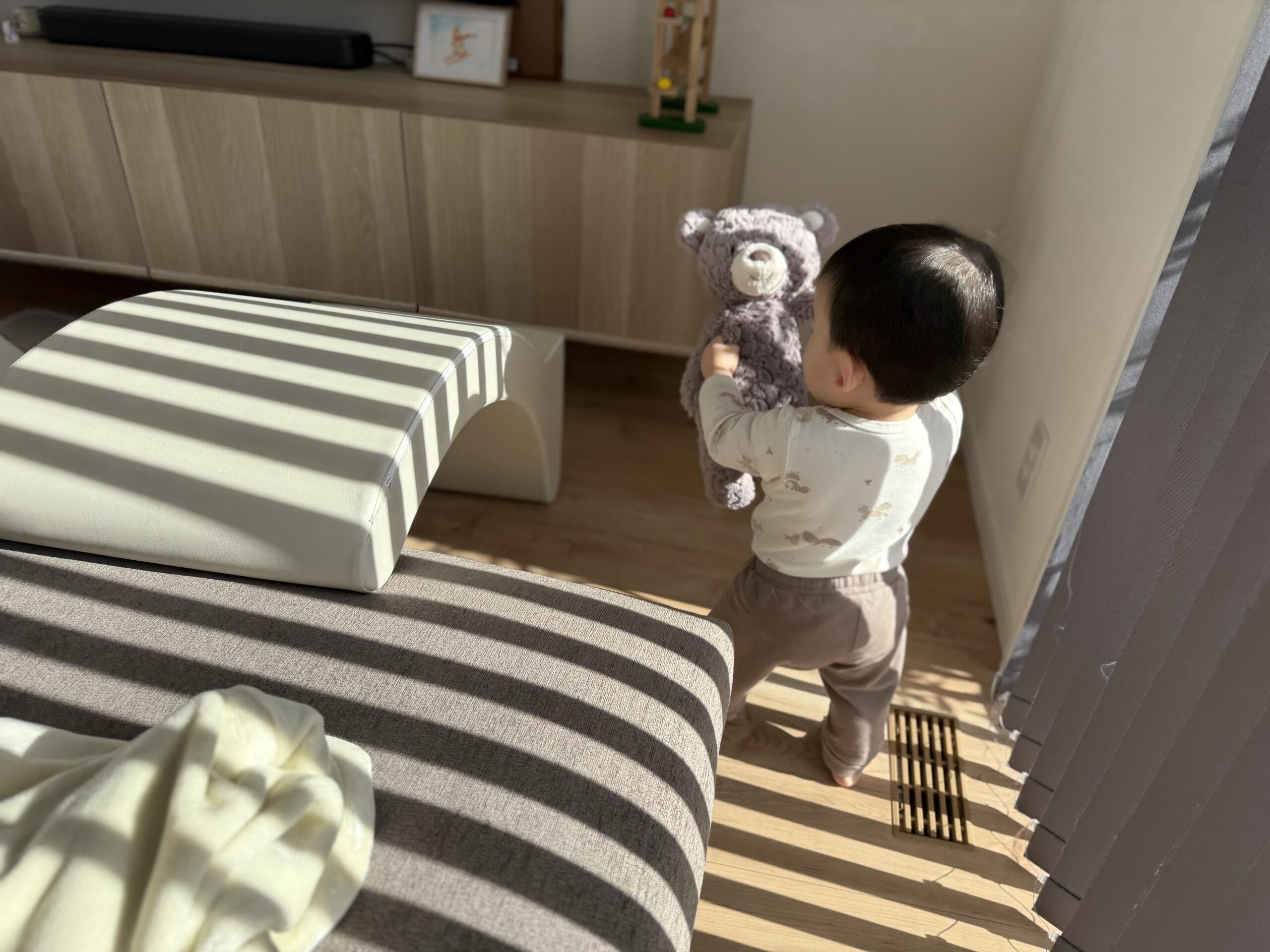 テディベアを抱きしめて歩く息子の後ろ姿