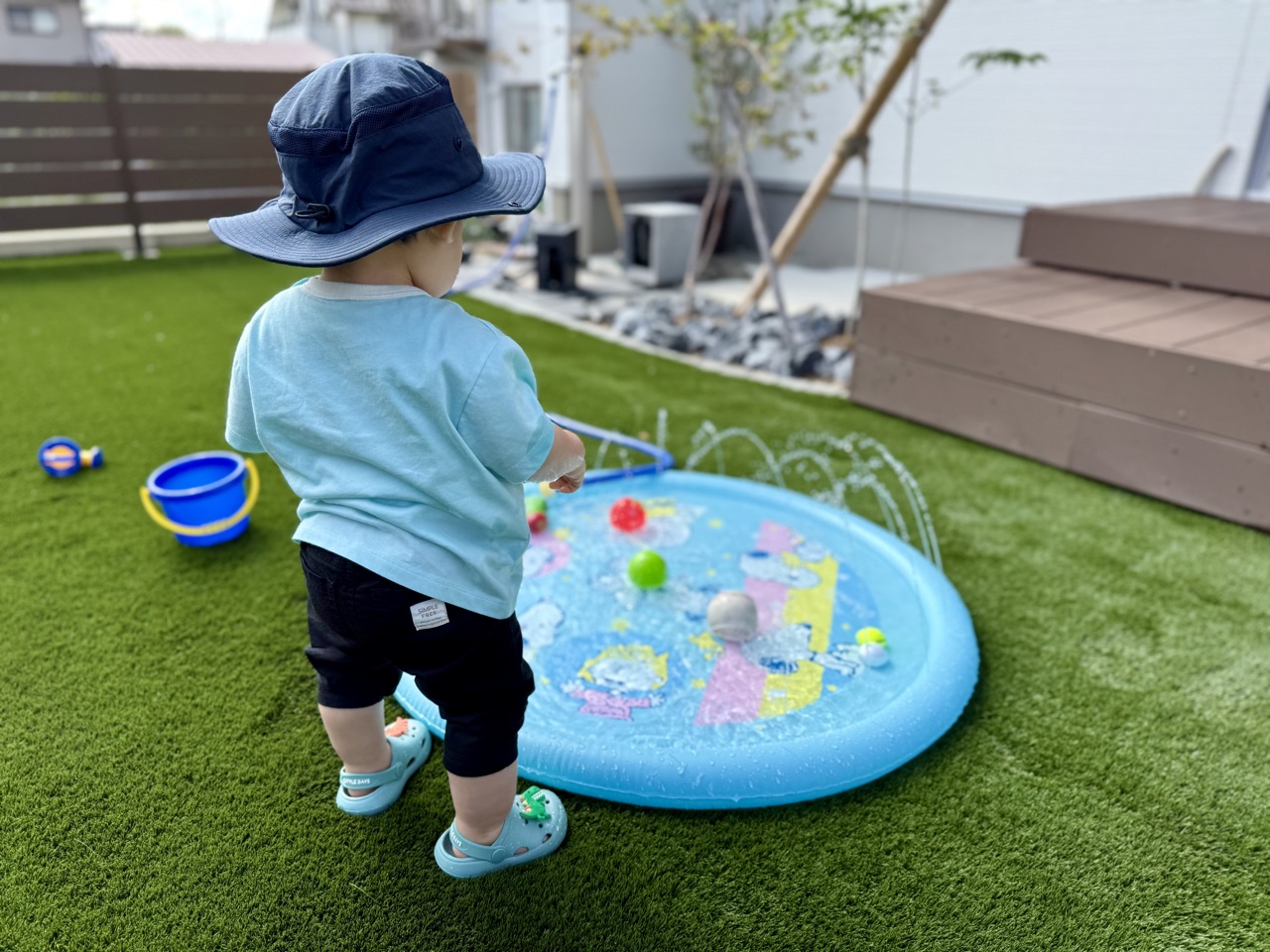 サンシールドハットをかぶって夏の水遊びをする子ども