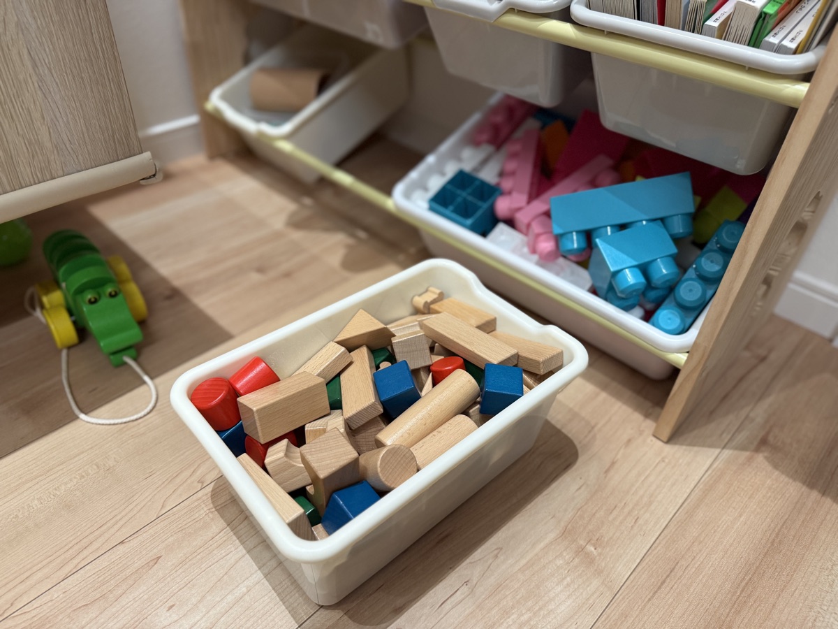 積み木のカゴを床に持ってきて遊んでいる様子