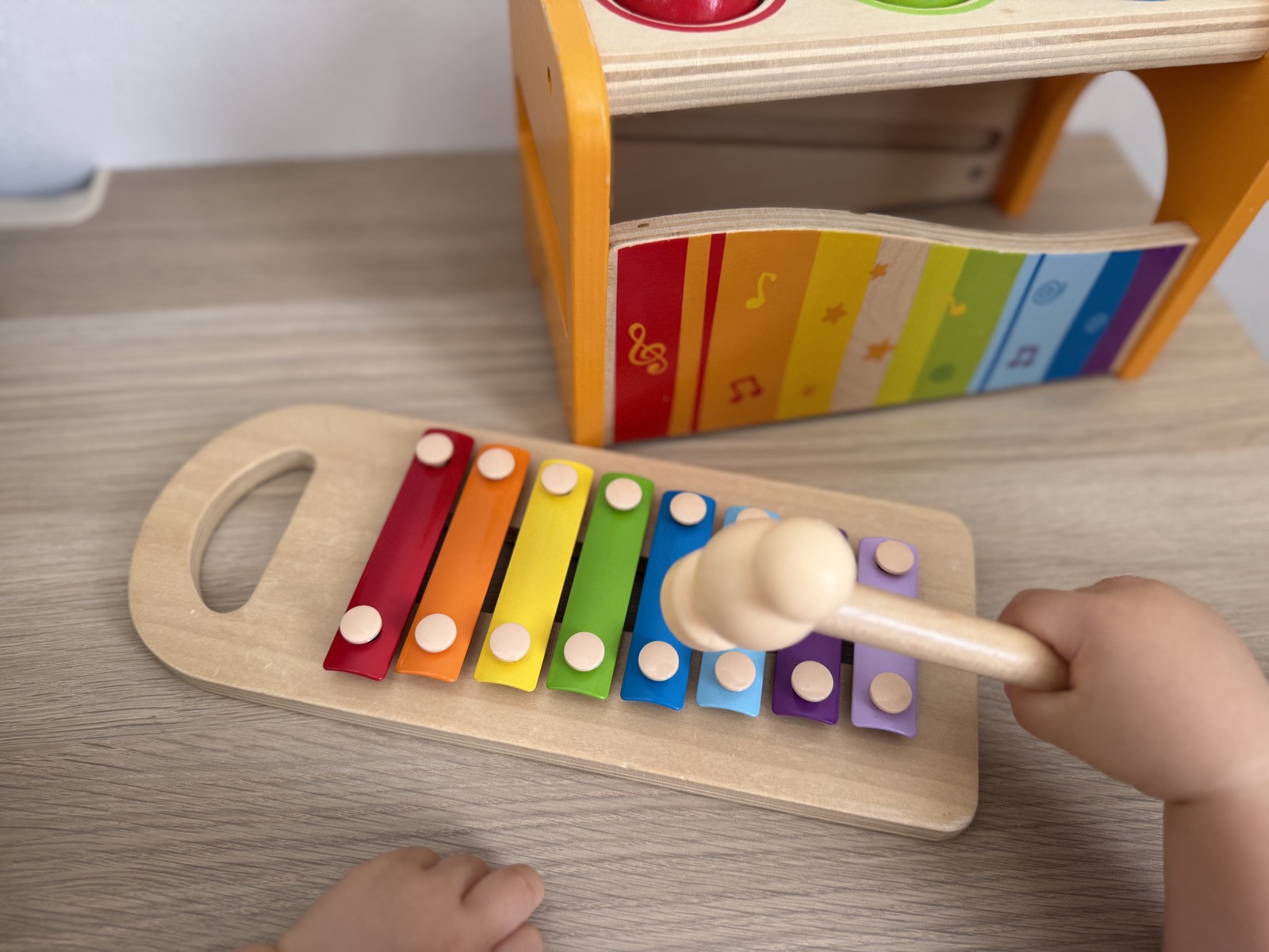 取り外した鉄琴を子どもが木のバチで叩いて遊んでいるところ