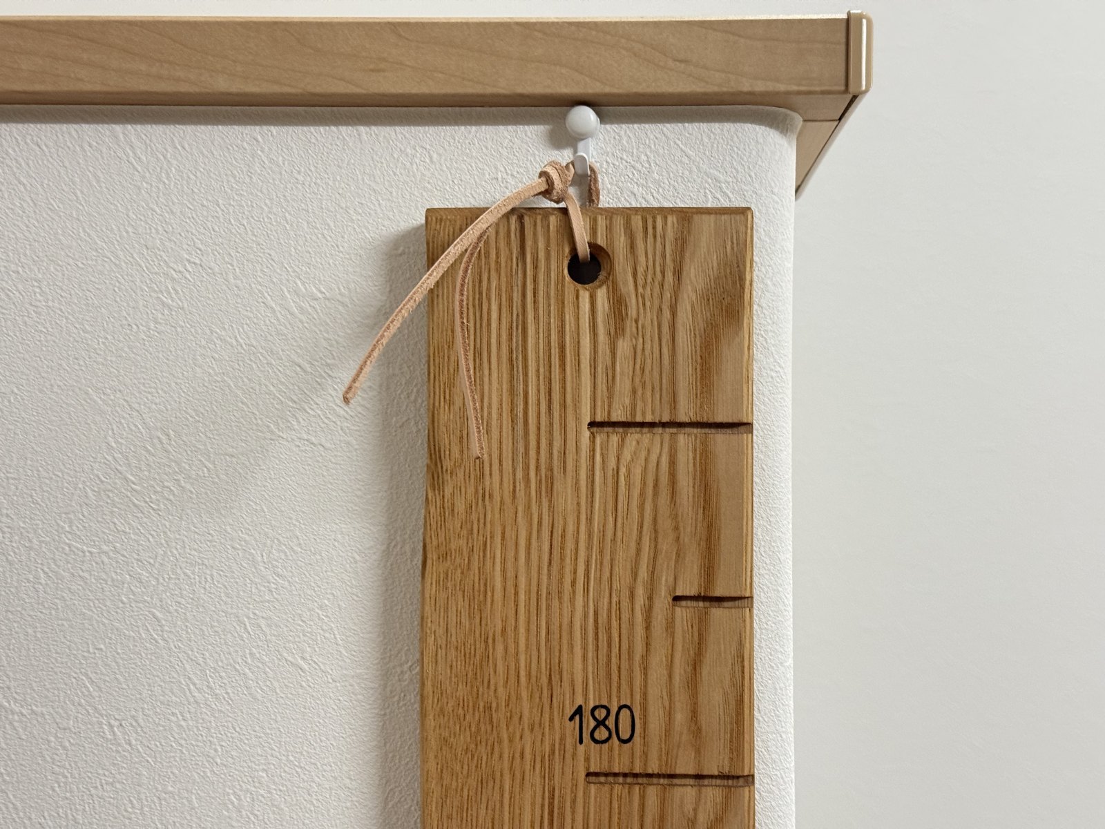いちばん上の革紐を壁のフックに掛けたところ