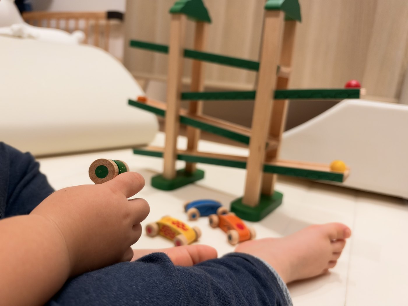 転がす前のどうぶつ車を握っている息子の手元とスロープ
